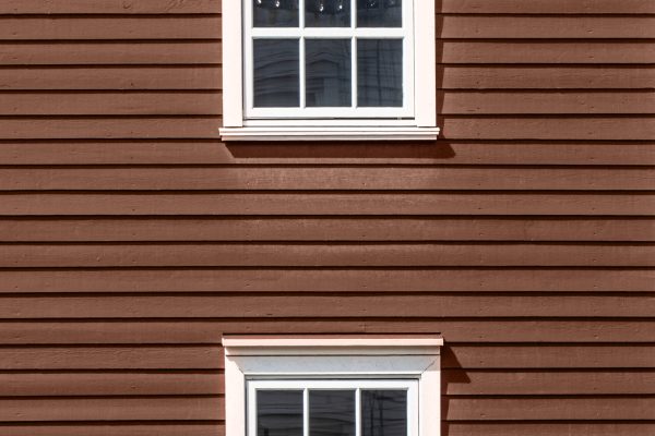 Two floors of windows on wooden facade. Demonstrating color of 2025 year